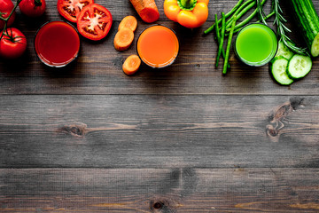 Fresh detox beverages with vegetables and fruits on dark wooden background top view copyspace