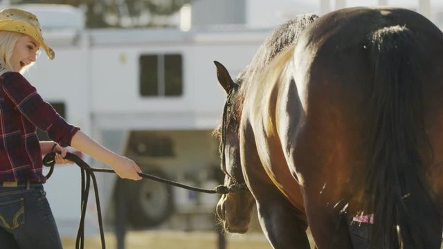 Medium slow motion panning shot of woman walking horse / Lehi, Utah, United States