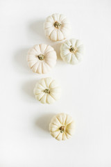 White pumpkins bunch on white background. Flat lay, top view.