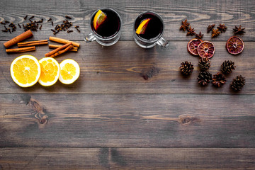 Ingredients for mulled wine. Spices cinnamon and badian, citrus fruits on dark wooden background top view copyspace