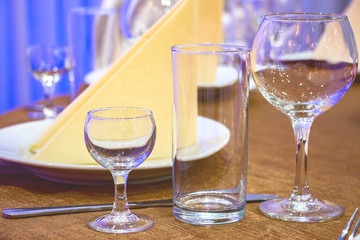 The table in the restaurant. On the table there are empty wine glasses, napkins and a plate