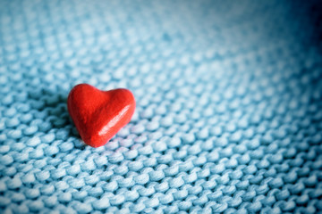 red small heart on a knitted background close-up. place for text, copy space