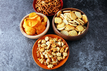 Salty snacks. Pretzels, chips, crackers in wooden bowls