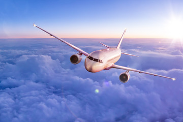 Obraz premium Samolot komercyjny lecący nad chmurami