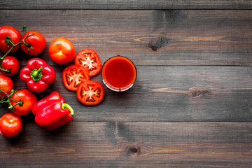 Red detox beverage with paprika and tomatoes on dark wooden background top view copyspace