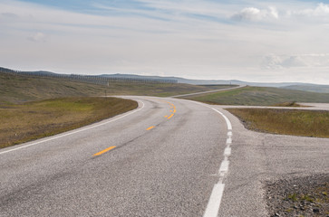 The road is far away against the background of stony hills