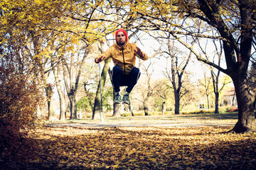 Jumping squats in park. Yang man exercise.