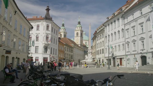 Wide slow motion panning shot of people in plaza / Ljubljana, Slovenia