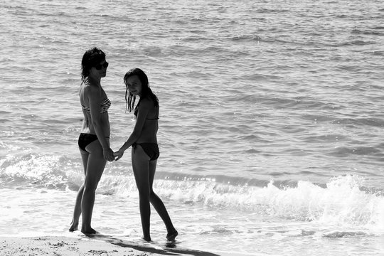 mother and daughter on the beach. black and white. photo.