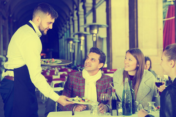 Fototapeta premium Waiter serving guests at terrace restaurant