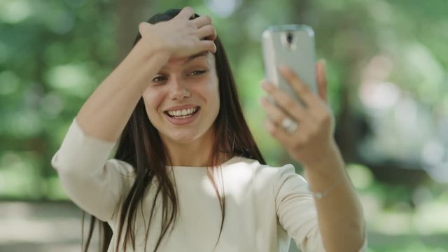 Close up of woman video chatting on cell phone in park / Kazanluk, Bulgaria