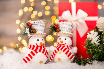 Christmas decoration on a wooden background with snowman, snow and  lights