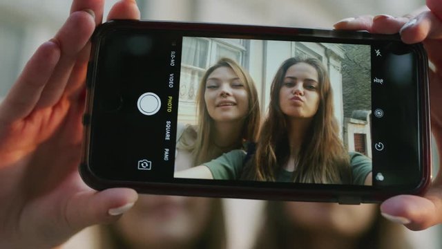 Close up slow motion shot of women posing for cell phone selfie / Plovdiv, Bulgaria