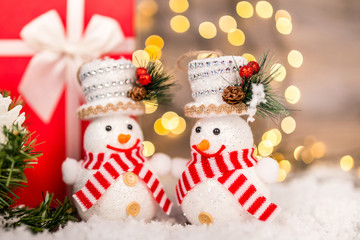 Christmas decoration on a wooden background with snowman, snow and  lights