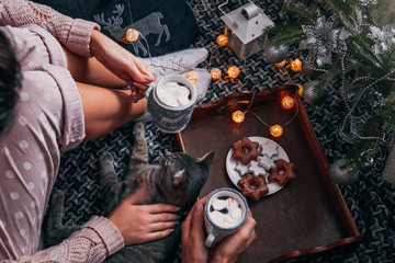 Couple having hot chocolate under the Christmas tree