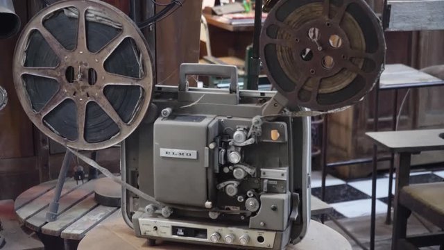 Old fashioned cinema projector. Vintage Movie projector with the film.