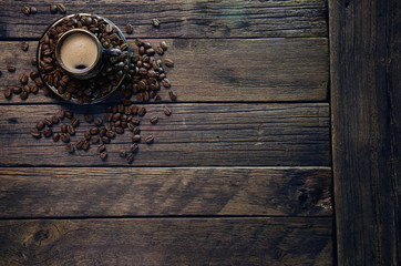 cups with hot coffee and grains on the board surface