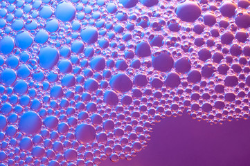 Abstract background of bubbles on water surface with a gradient from violet to blue