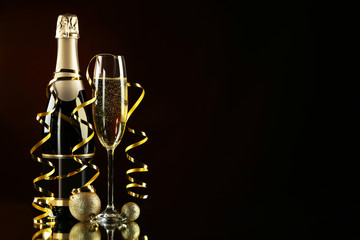 Champagne bottle with glass on black background