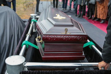 coffin before sinking into grave. coffin on elevator. coffin on system of automotical sinking into...