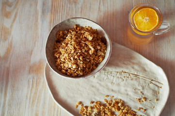 Healthy Breakfast of Champions. Muesli , a glass of water with a slice of orange. Ceramic handmade