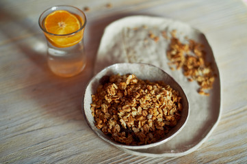 Healthy Breakfast of Champions. Muesli , a glass of water with a slice of orange. Ceramic handmade