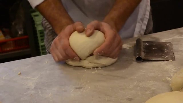 Chef kneading pizza bread dough