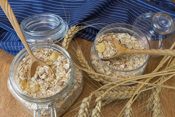  Muesli, breakfast cereal, oatmeal in a glass container on a wooden table. Rustic food.