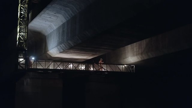 Structural Engineers Working at Night on a Concrete Bridge Inspecting for Cracks and Structural Damage