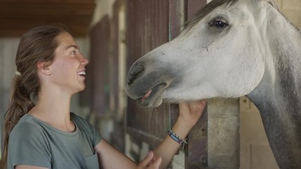Close up slow motion shot of girl petting horse / Lehi, Utah, United States