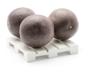 Three passion fruits on a pallet isolated on white background.