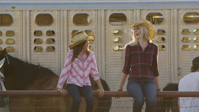 Medium slow motion shot of wind blowing hair of woman and girl on fence / Lehi, Utah, United States