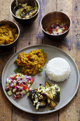 Indian meal with masoor dal - lentil curry, dahi baingan, rice and salad