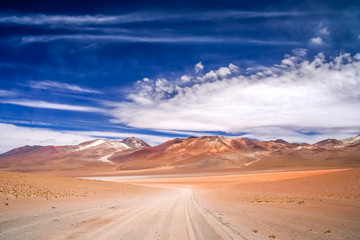 Fototapeta na wymiar Sandy and gravel desert road through Altiplano
