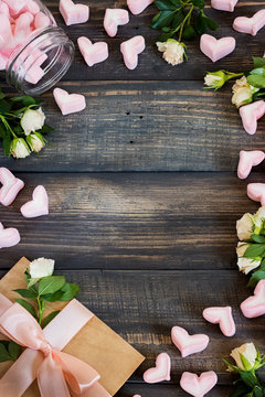 Marshmallow hearts, love letter and flowers on an old wooden background