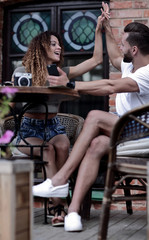 Portrait of a young  couple sitting down at a cafe terrace