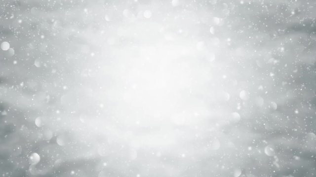 Snowfall on out of focus abstract blurred winter silver snow bokeh light nature background.