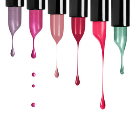 Melting colored lipsticks with falling drops down on white background