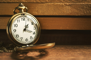 Vintage pocket watch on wooden board