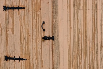 деревянная закрытая дверь на замке на деревянной стене дома 