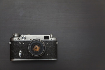 Vintage Film Camera On Black Wooden Background Technology Development Photographer Concept with copy space. Top View