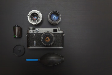 Vintage Film Camera And Accessories On Black Wooden Background Technology Development Concept with copy space. Top View