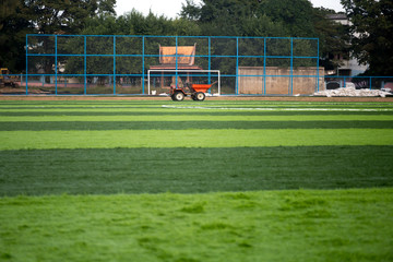 Obraz premium Orange truck with Artificial bright and dark green grass