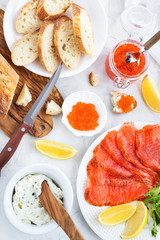 Delicious lunch with salted salmon, red caviar, fresh bread and cream cheese