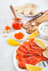 Delicious lunch with salted salmon, red caviar, fresh bread and cream cheese