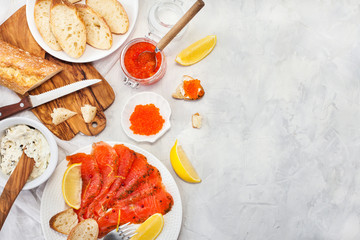 Delicious lunch with salted salmon, red caviar, fresh bread and cream cheese