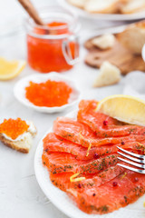 Delicious lunch with salted salmon, red caviar, fresh bread and cream cheese