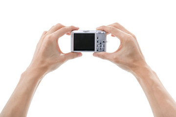 Digital camera in hand isolated on white background