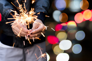 Yiung girl holding a sparkle with bokeh light