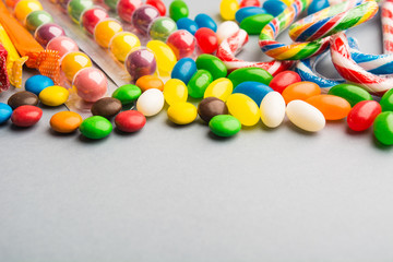 Different colorful candies on grey background
